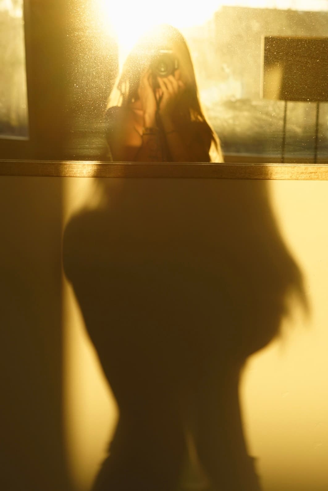 Chandra in golden-hour light — a soft self-portrait through sunlit glass